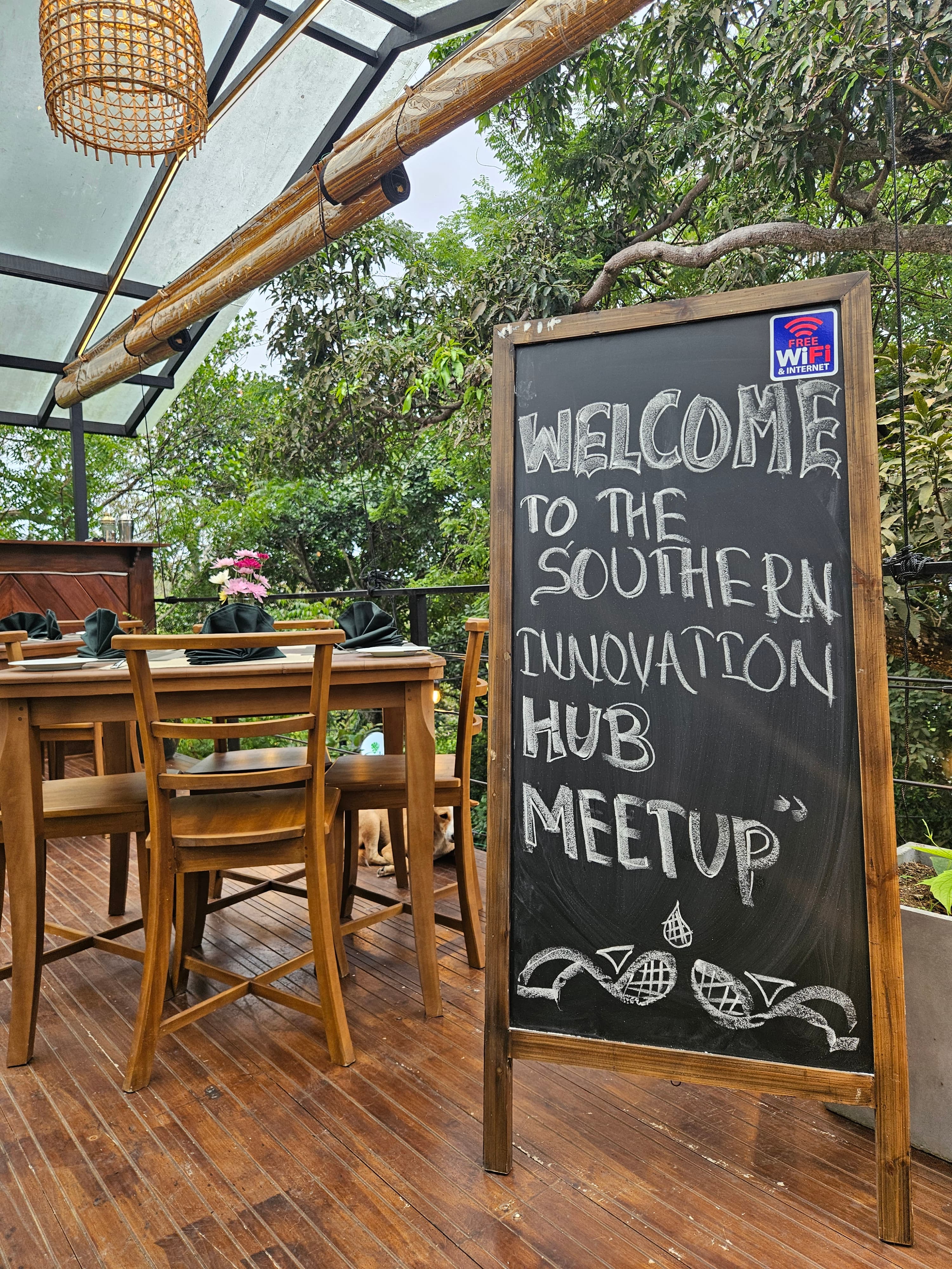 A founder fireside chat on a wooden deck, speaker with microphone facing a seated circle